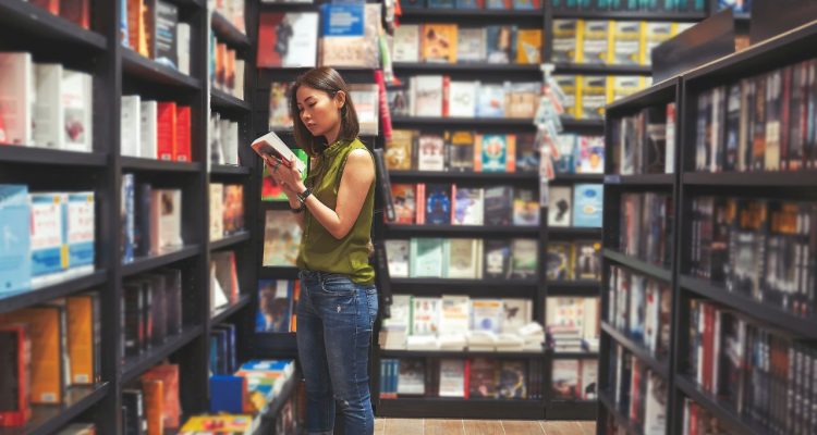 A woman inspecting a book in a bookstore