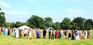 People gathered outside in a field setting up for Lughnasadh