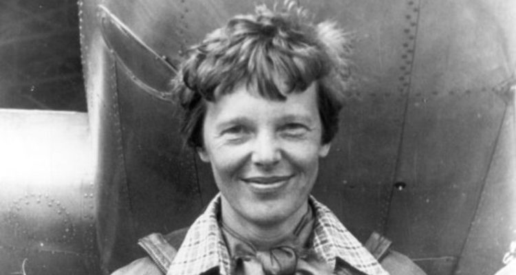 Amelia Earhart posing with her plane