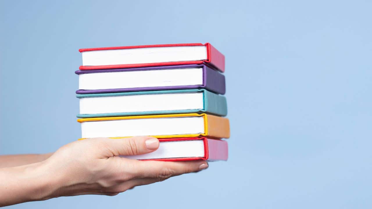 can-books-be-recycled-how-to-make-an-affordable-difference-hand-holding-colorful-book-stack