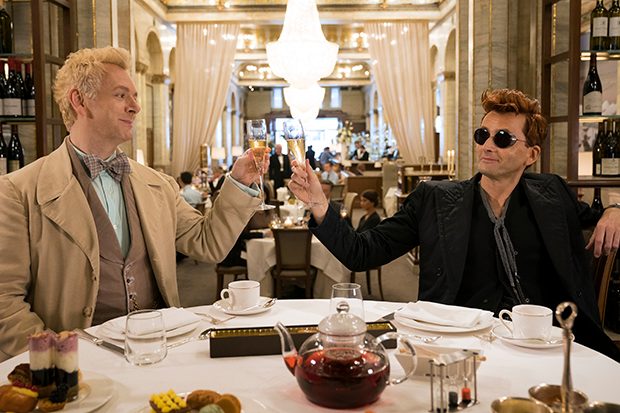 Aziraphale and Crowley dining at the Ritz and holding champagne glasses