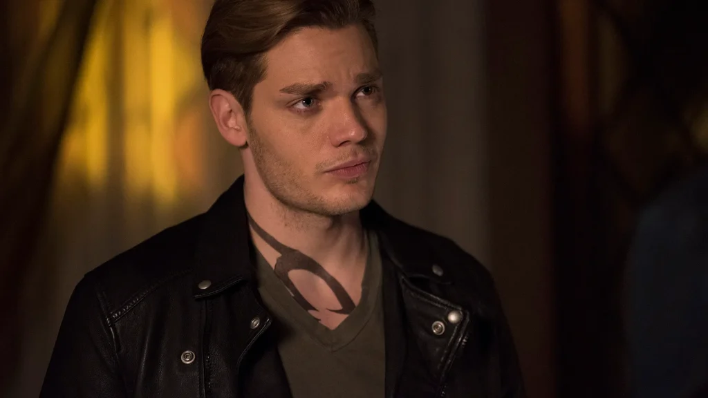Jace Herondale from TV show Shadowhunters dressed in a green shirt and a black leather jacket.