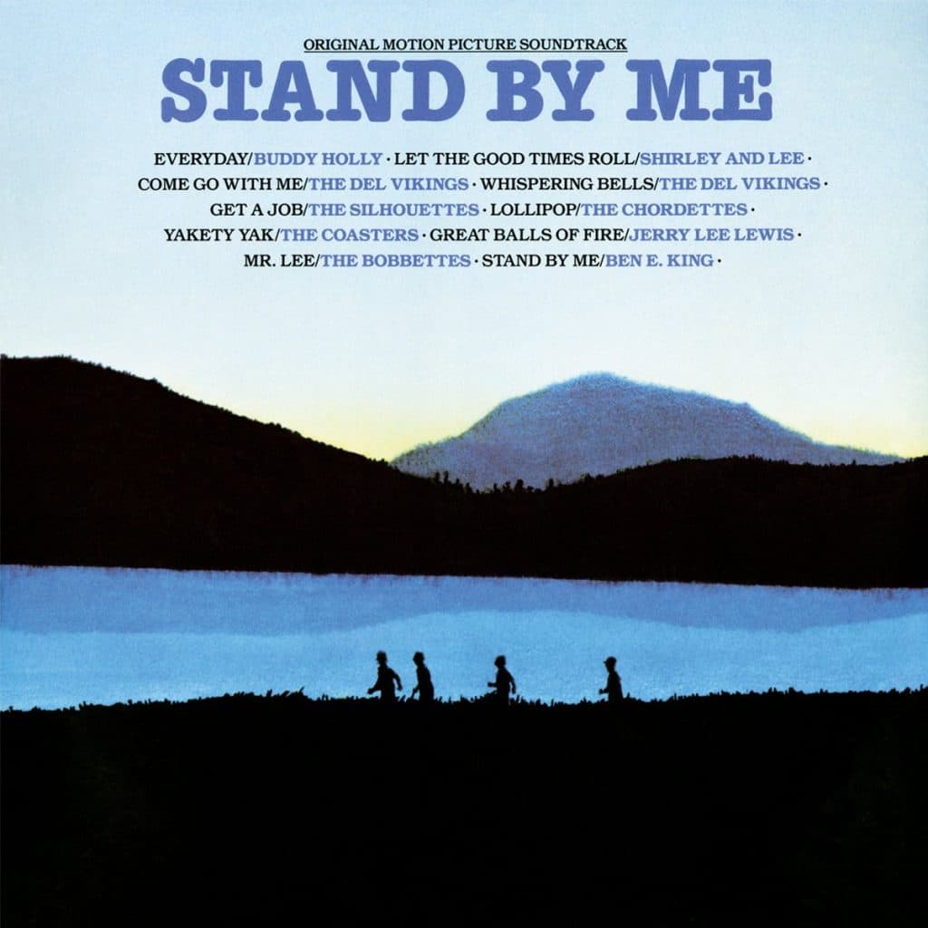 Stand my Me album cover, shows silhouettes of four boys walking along a river with hills in the distance.