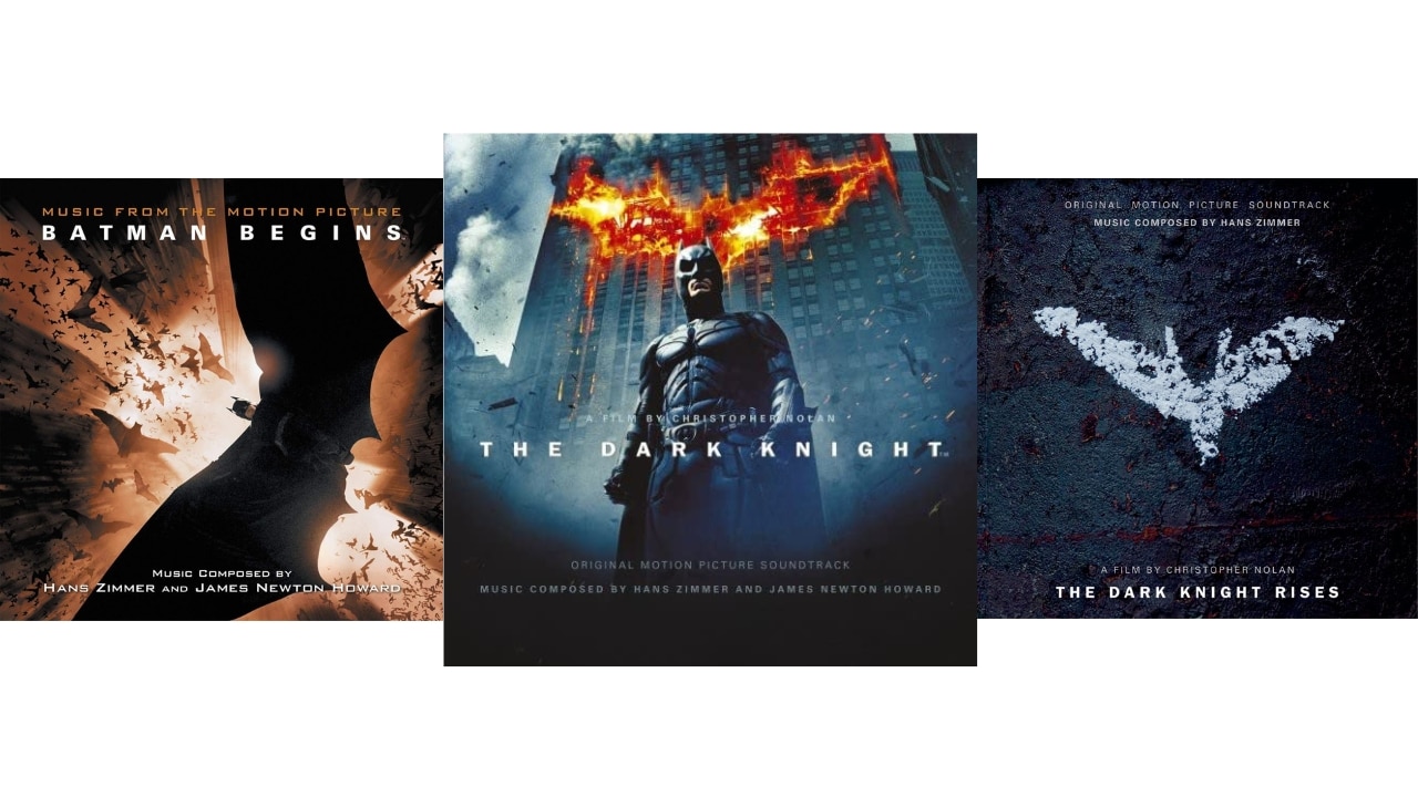 Three soundtrack album covers for The Dark Knight Trilogy. From left to right: Batman begins, shot of batman and bats looks up through skyscrapers; The Dark Knight, Batman in front of a skyscraper with a flaming bat signal; The Dark Knight Rises, white bat symbol in chalk on the ground.