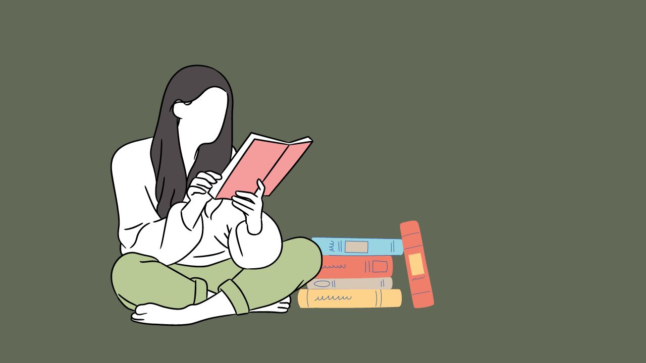 woman cross legged reading a book with a stack of books next to her