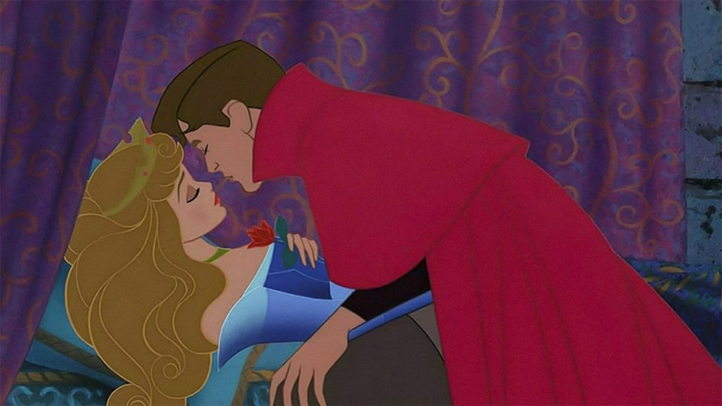 Prince in red cloak leaning into kiss blonde sleeping woman holding a rose image