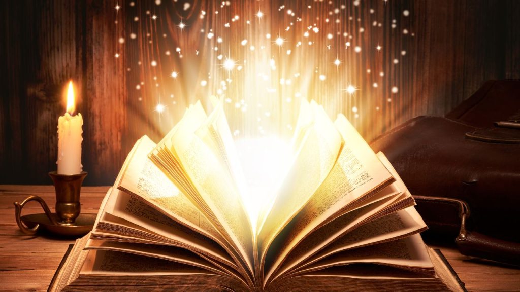 An open books with light and sparkles coming out with an old candle next to the book