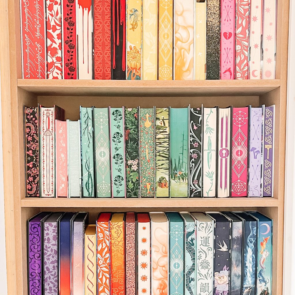 A book shelf with the spines of the book pointed in. The pages are stenciled with intricate, colorful designs.