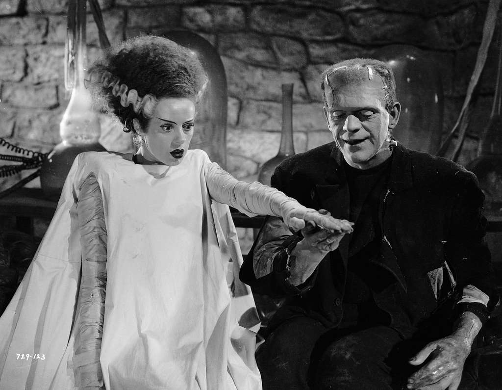 The Bride of Frankenstein and Frankenstein's creature holding hands.
