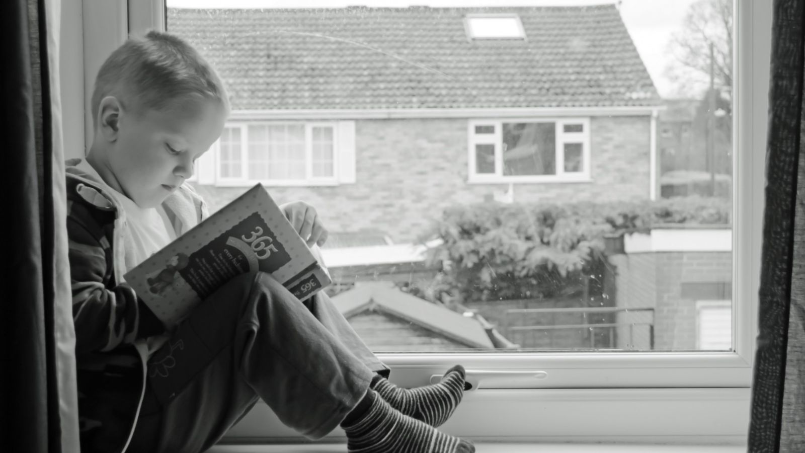 child-reading-in-window
