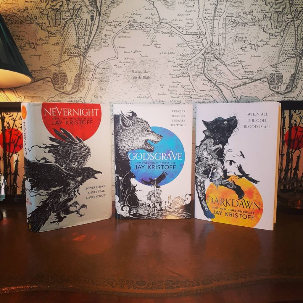 @fantasyphile photo of three Jay Kristoff books stoop up in front of a map