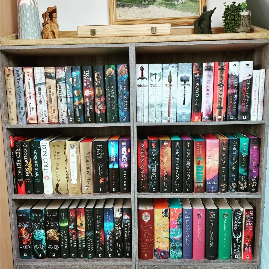 @fantasyphile photo of an organized bookshelf with decorations on top