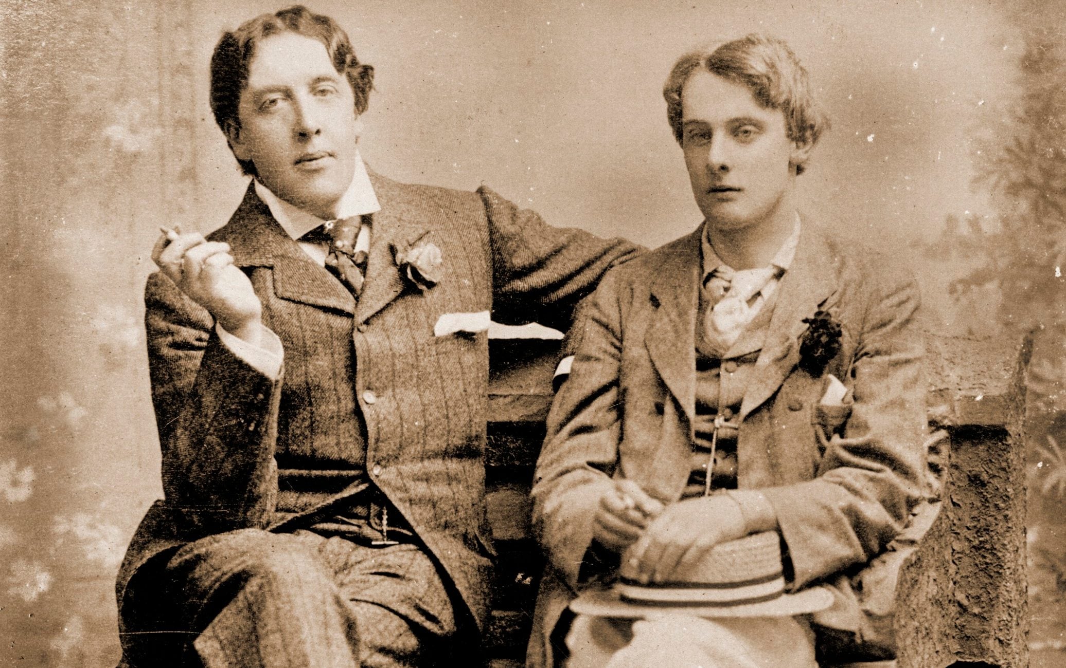 Oscar Wilde and Lord Alfred Douglas sitting next to each other
