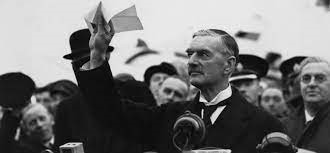 UK Prime Minister Neville Chamberlain holding up a piece of paper at a speech