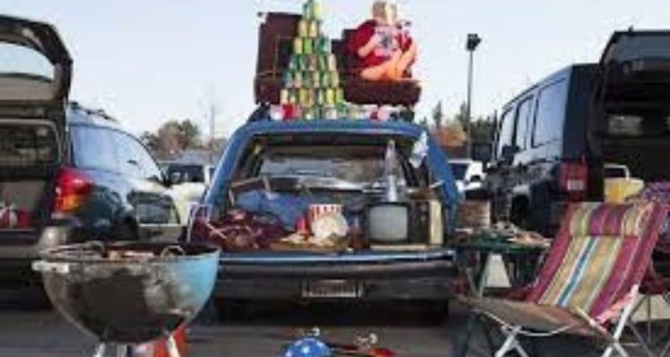 Car with tailgating supplies like an umbrella, a tent, a Tv, and more
