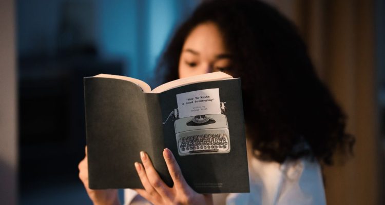 A girl reading a book about how to write a screen play.