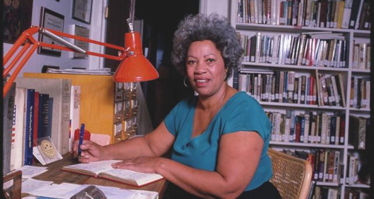 Toni Morrison writing at a desk.
