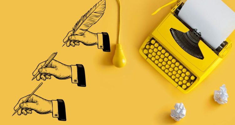 yellow typewriter with wadded balls of papers and three different hands holding a quill, pen, and pencil.