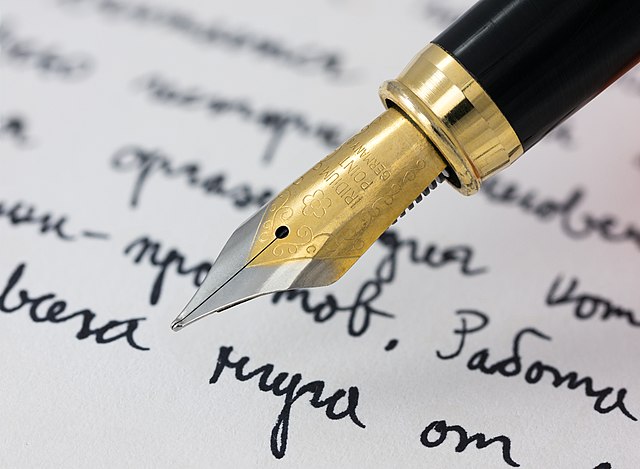 A pen with ink rests above written words, symbolizing the lawsuit.