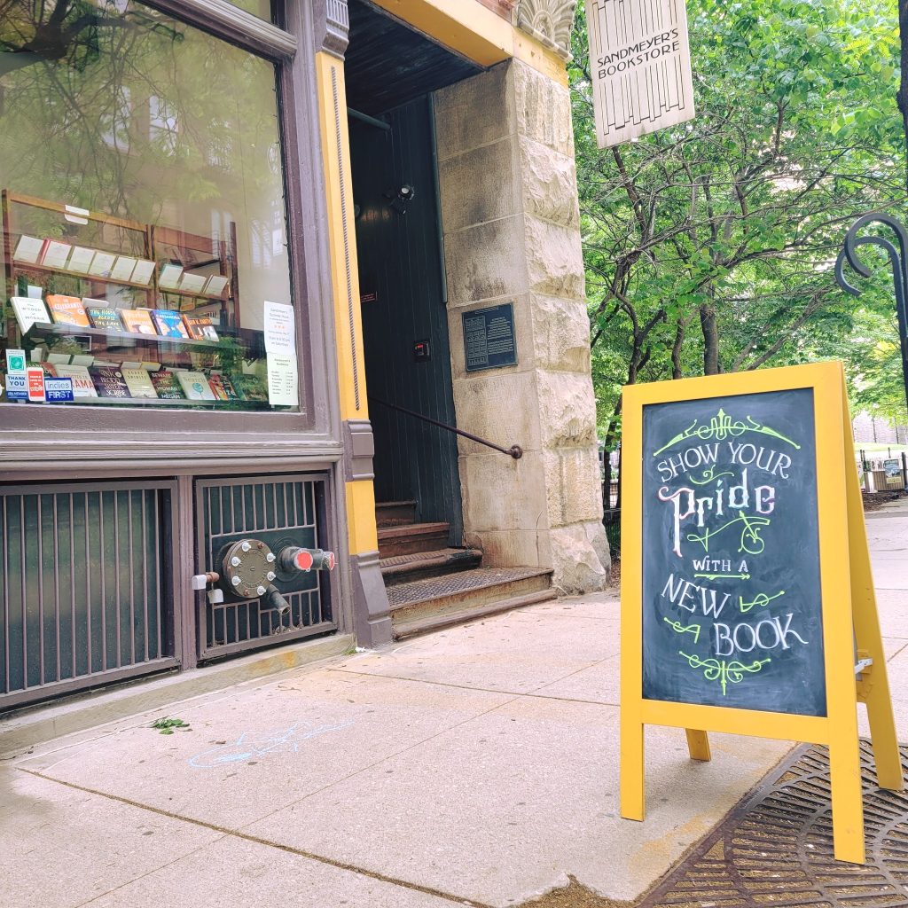Bookstore front with steps leading into the doorway with a chalkboard in front of it.