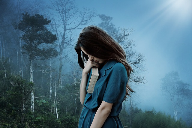 A dark background in the woods with a girl in a blue dress holding a book.