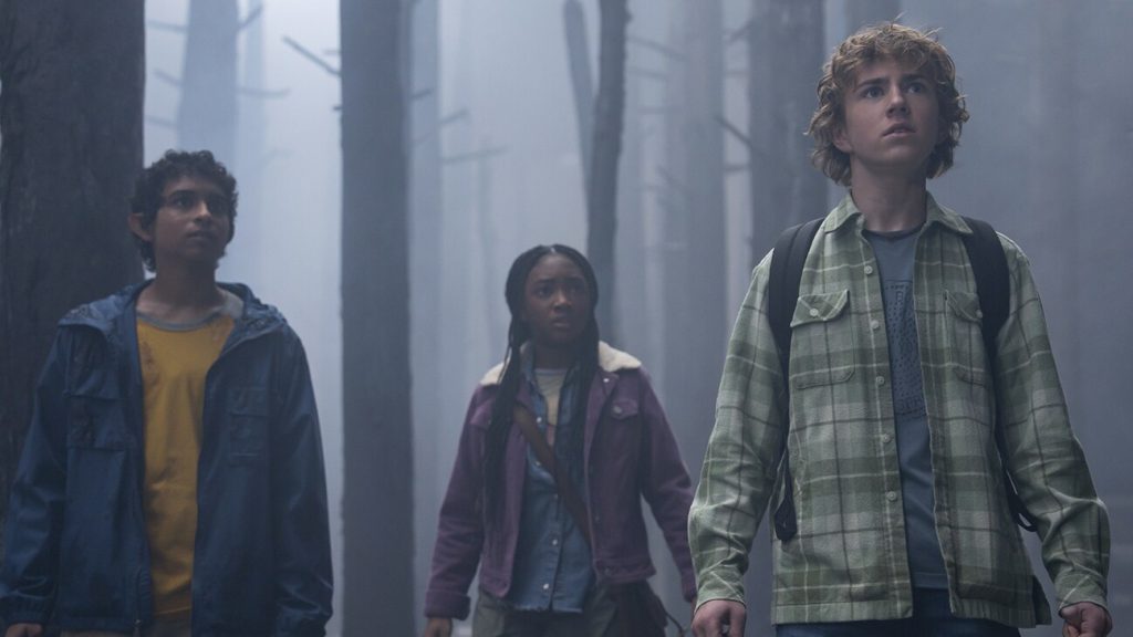 Percy Jackson TV show featuring Leah Jeffries in a jacket, Walker Scobell in a flannel, and Aryan Simhadri in a blue jacket.