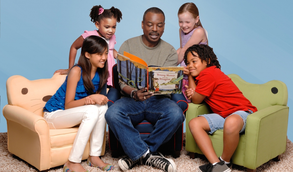 Kids surrounding Levar Burton as he reads a book