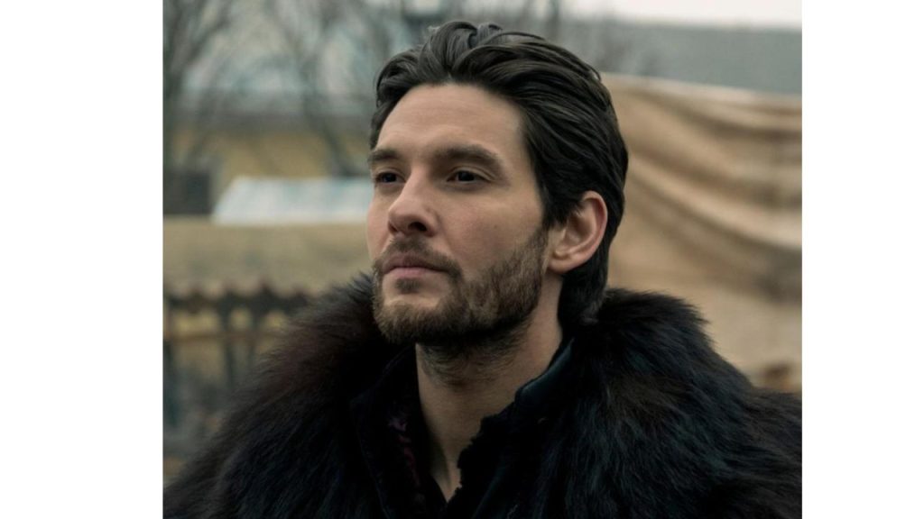 dark haired man with facial hair wearing large fur cloak
