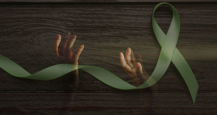 hands reaching upwards under a green mental health ribbon