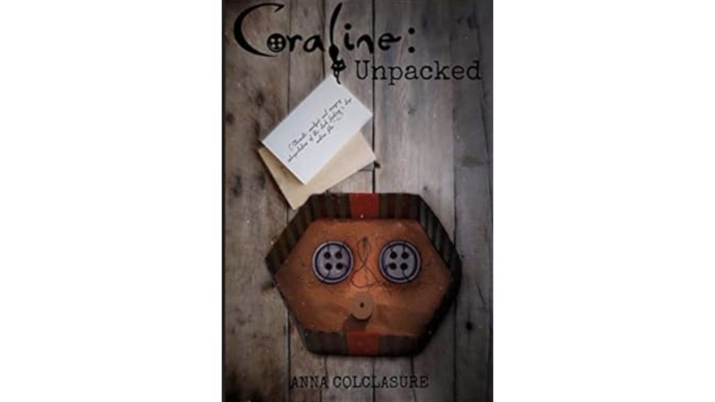 Front cover of Anna Colclasure's Coraline: Unpacked, showing a box with two buttons and sewing material, and a small note with writing in cursive. 