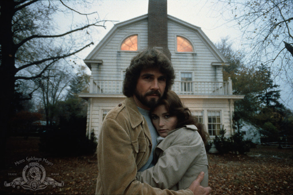 George and Kathy Lutz embracing each other outside of the Amityville house.