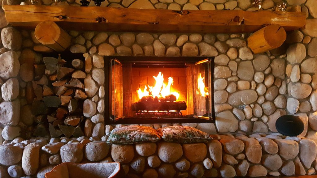 Fireplace with cozy pillows and firewood