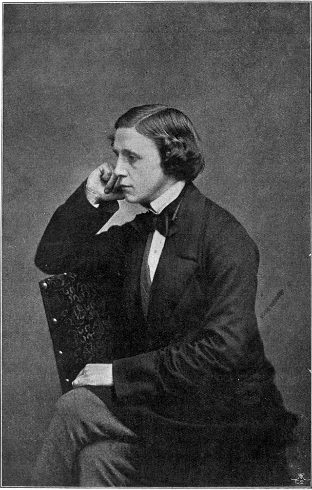 Lewis Carroll sits in a chair.