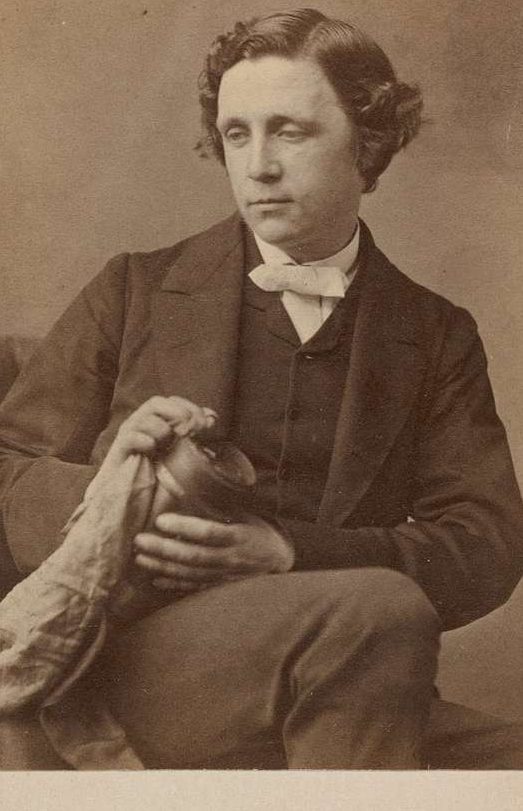 Lewis Carroll sitting and looking off to the side.