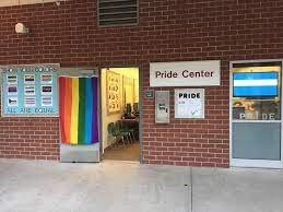 The outside brick wall of the Mt. San Antonio College Pride Center with a pride flag and center doorway