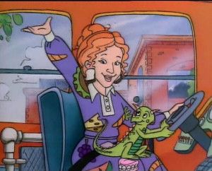 Ms. Frizzle on the school bus in a purple dress with her orange hair pulled up into a bun. 