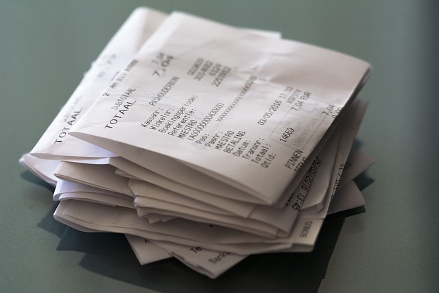 A stack of receipts with a gray background.