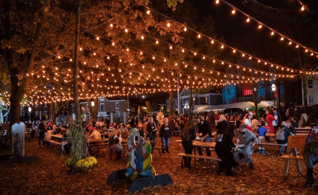 Nighttime festivities under lights set up in between trees
