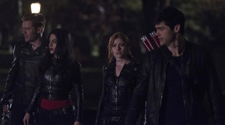 Jace, Izzy, Clary, and Alec all dressed in black leather at night outside.