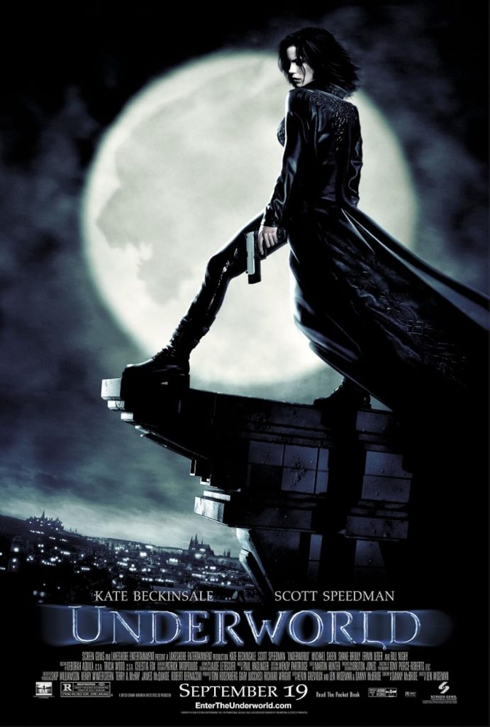 2003 Underworld film poster, Kate Beckinsale as Selene standing atop a building in a black leather outfit and holding a gun while the full moon with the shadow of a werewolf face overlaid on it looms behind her.