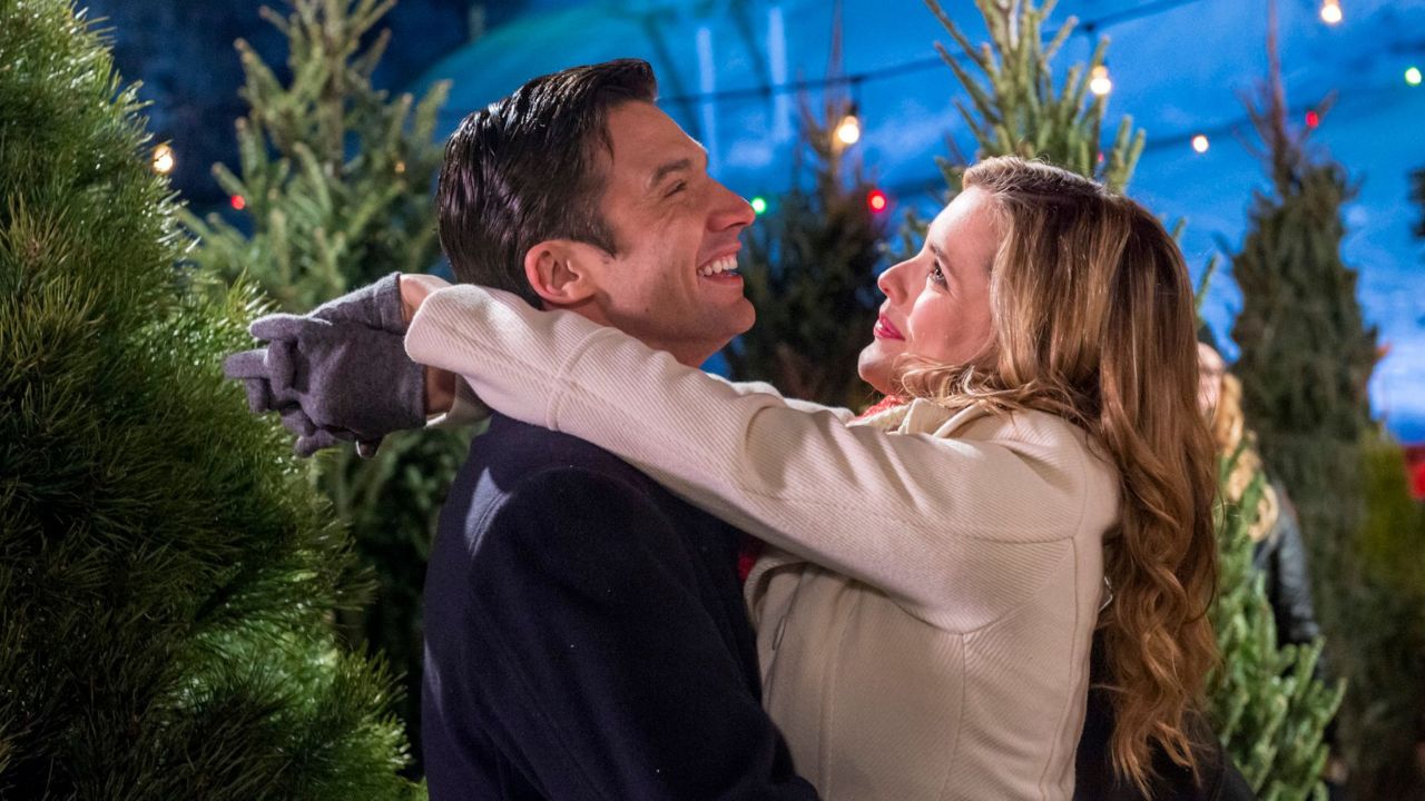 Cynthia and Steve from 'A Perfect Christmas' laughing and hugging in a Christmas tree farm