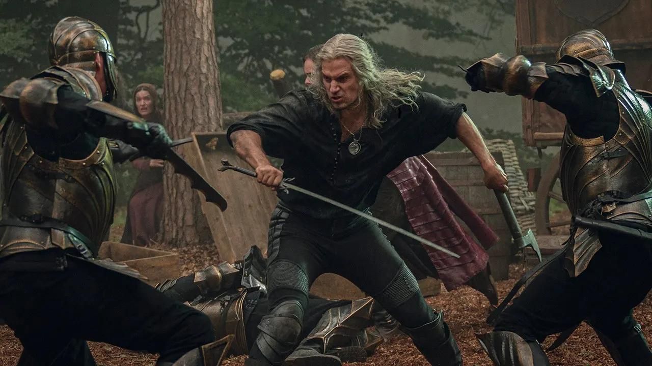 Geralt of Rivia fighting off two knights with a sword in Netflix's adaptation of The Witcher Saga.