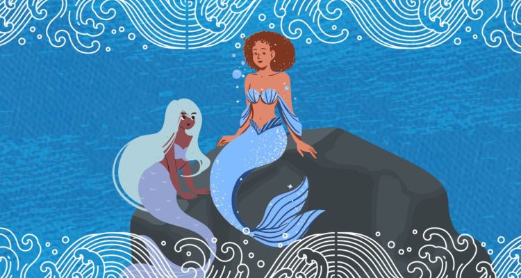 two female mermaids sitting on a sea rock in the ocean
