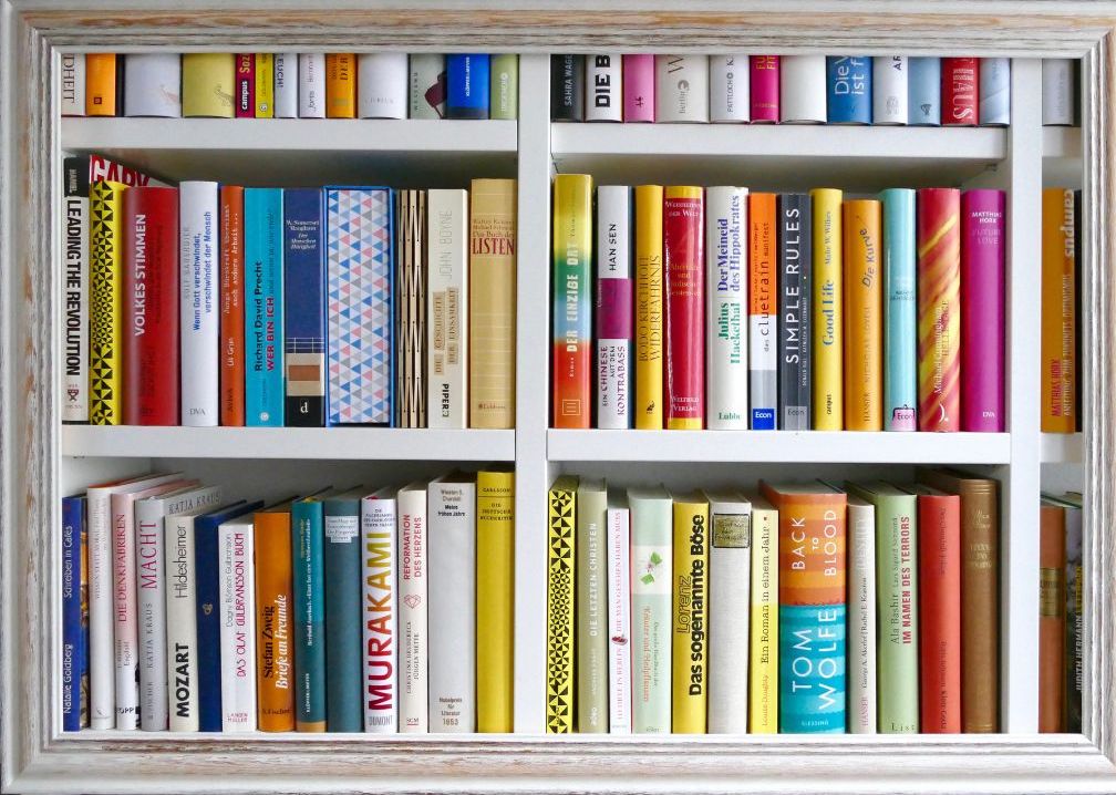 Image of a tightly packed bookshelf with a wooden frame around the edges of the photo.