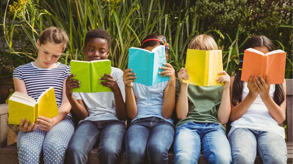 Image of five children all sitting down and reading different books.