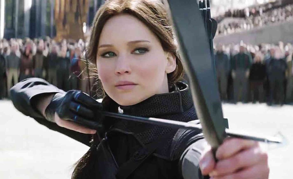 Brunette woman dressed in black holding a bow and arrow