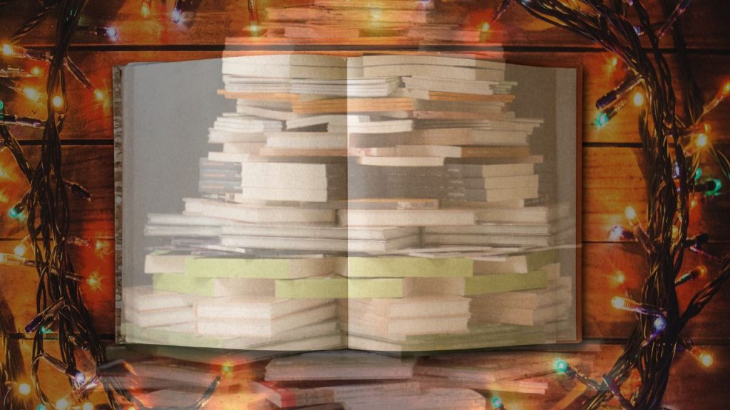 christmas trees stacked in a christmas tree formation with a book and wreath made of lights