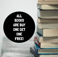 A stack of books besides a black circle advertising a buy one get one book sale