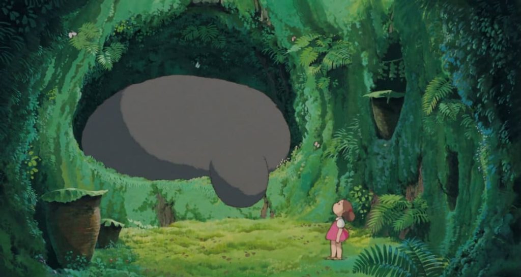 Mei Kusakabe looking at Totoro while surrounded by greenery