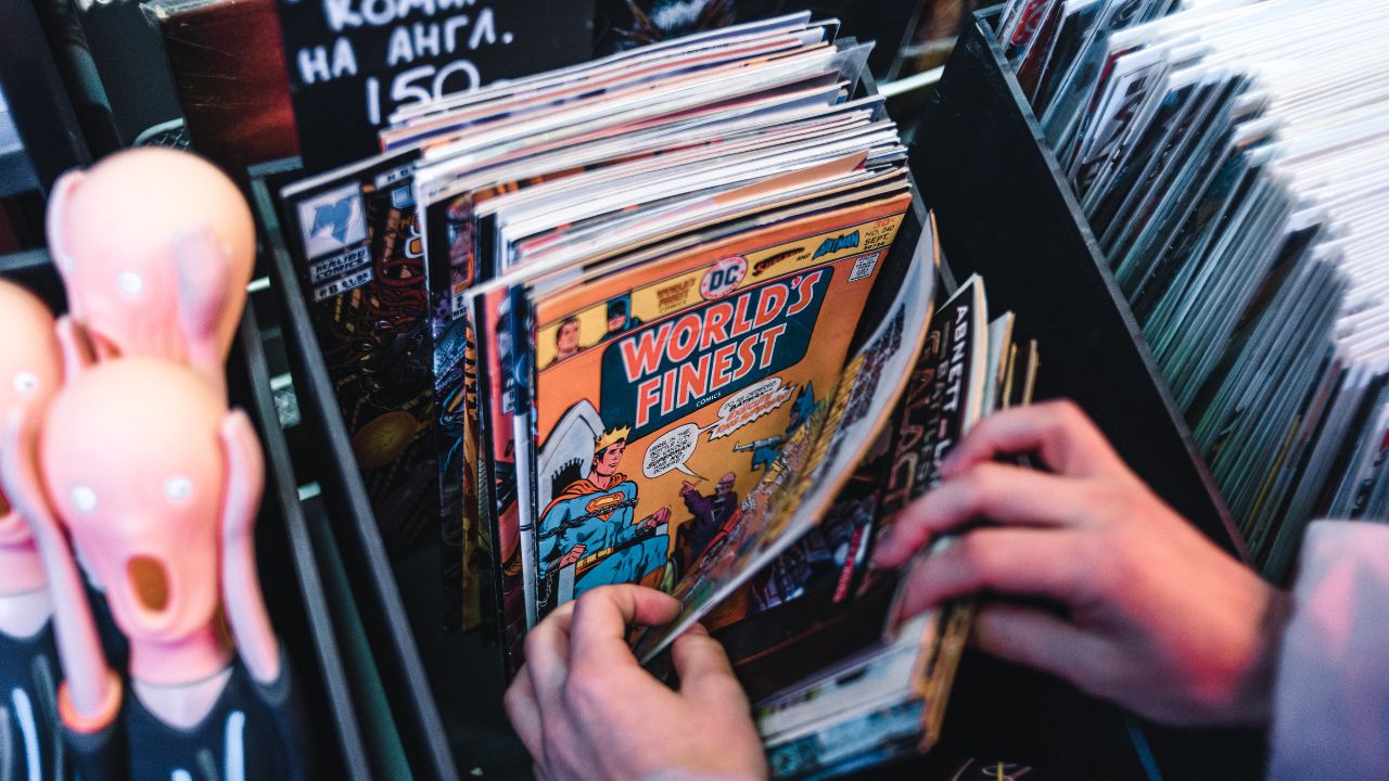 Hands searching through a collection of comic books.
